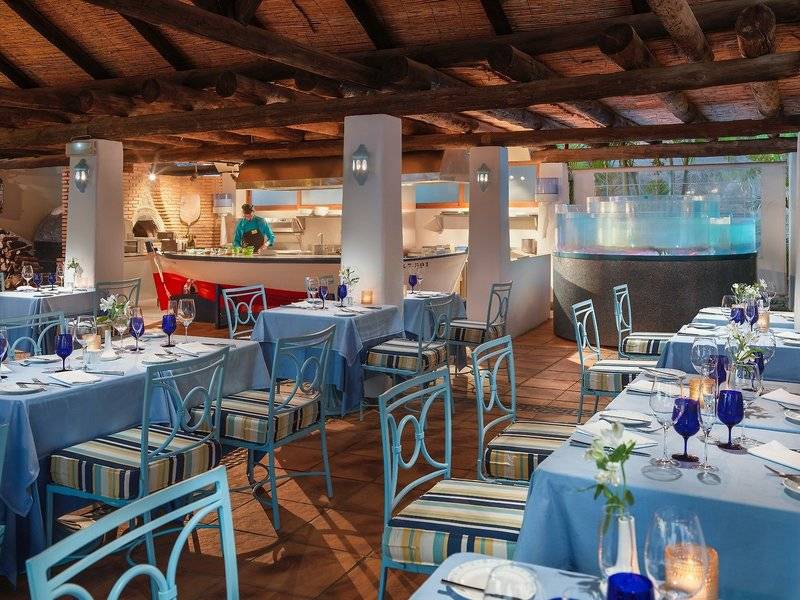 Innenansicht des Restaurants im Hotel Jardin Tecina mit blauen Tischen und Stühlen.
