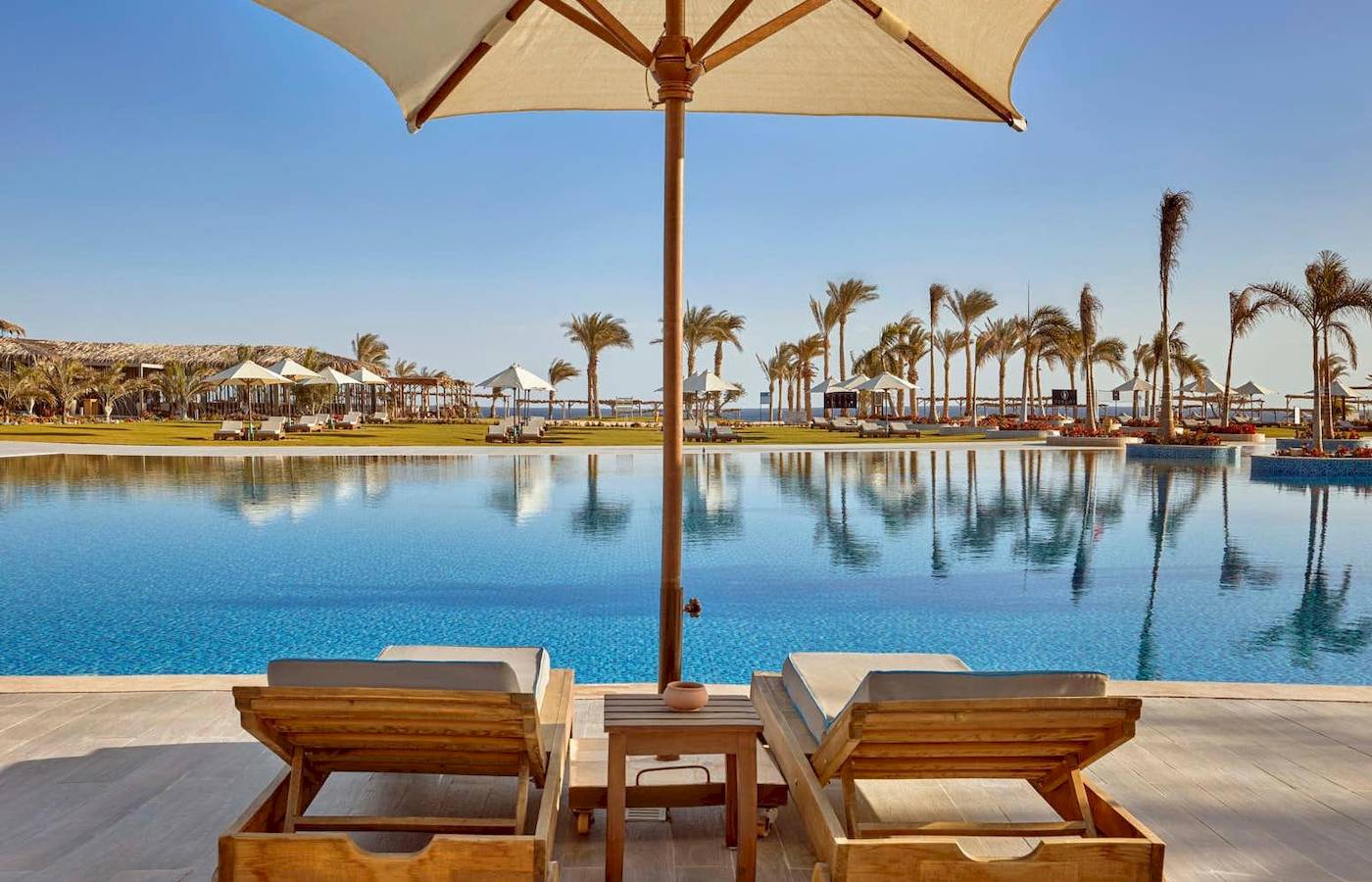 Poolbereich des Steigenberger Resorts Alaya mit zwei Liegen und einem Schirm