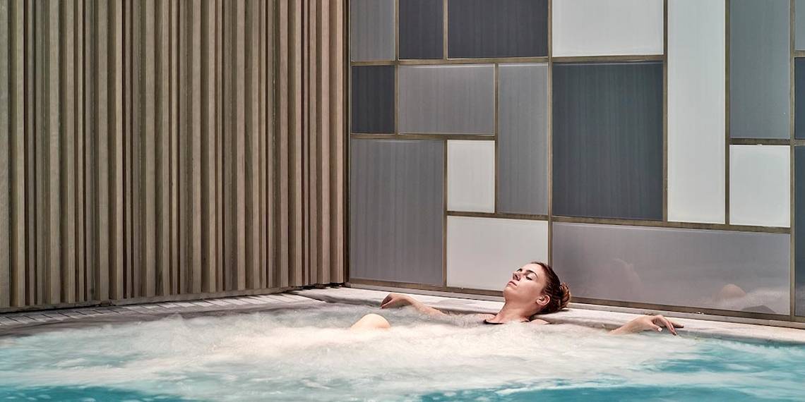 Eine Frau genießt ein entspannendes Bad im Schwimmbad des Myconian Ambassador Relais & Chateaux.