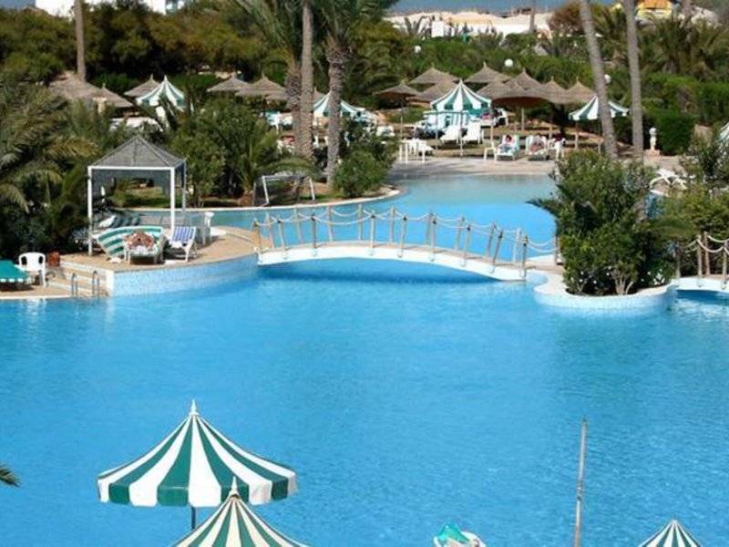 Außenpool des Djerba Holiday Beach Hotels mit Brücke und Sonnenschirmen