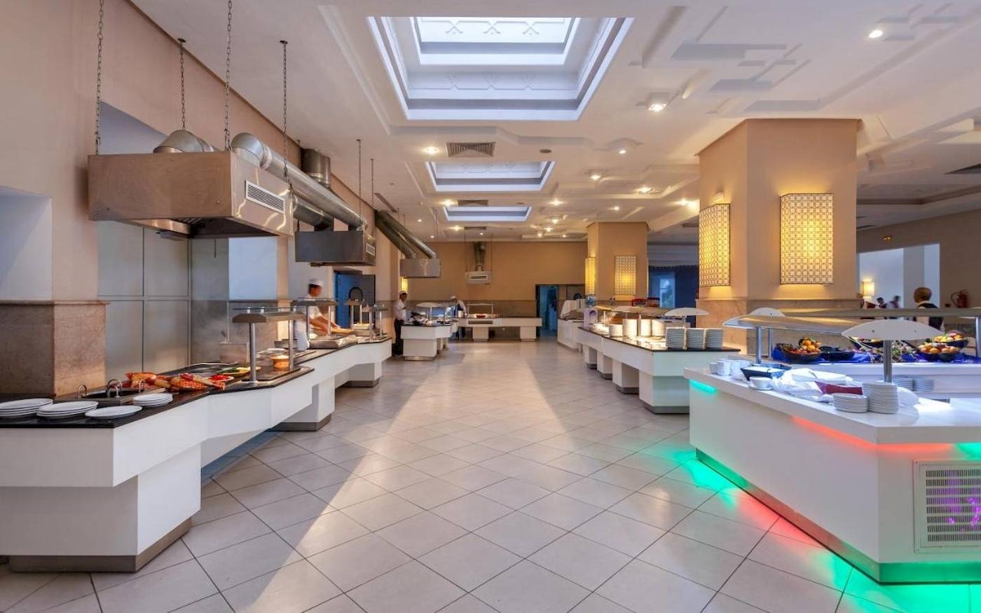 Foto von der Inneneinrichtung des Restaurants im Djerba Holiday Beach Hotel mit gepolsterten Stühlen und Buffets.