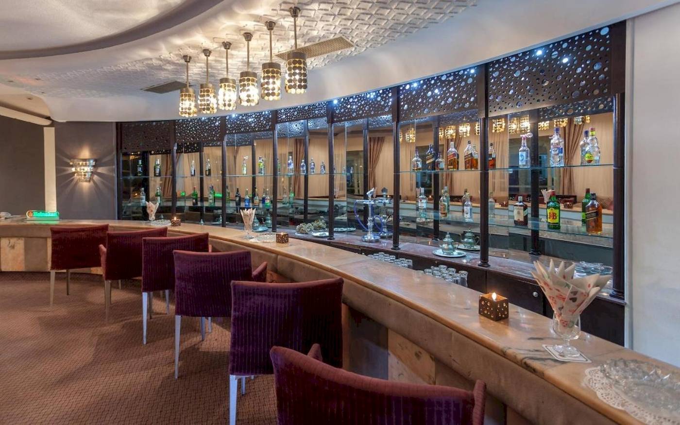 Innenansicht der Bar im Djerba Holiday Beach Hotel mit Stühlen und Theke.