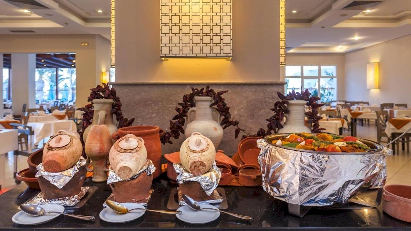 Restaurant im Djerba Holiday Beach Hotel mit verschiedenen Speisen und Geschirr.