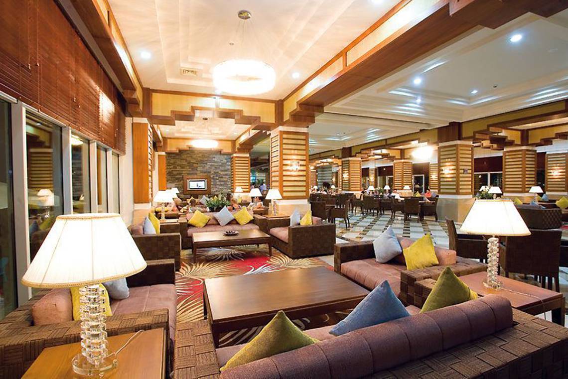 Lobby des Crystal Deluxe Resort & Spa mit Sofas, Lampen und Tischen