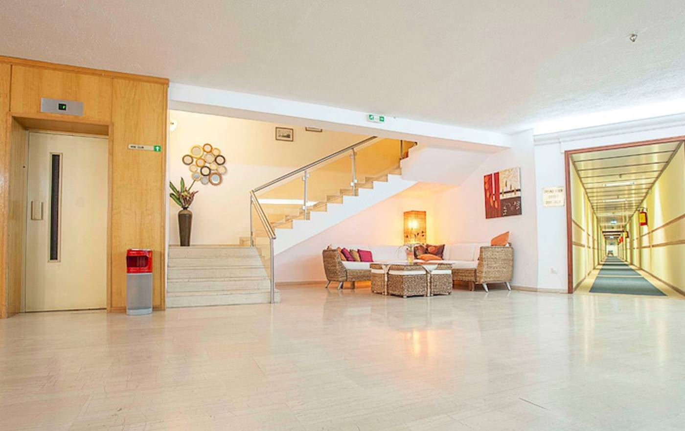Empfangsbereich des Irene Palace Beach Resorts mit modernem Design, Treppen, Sofas und Dekor.