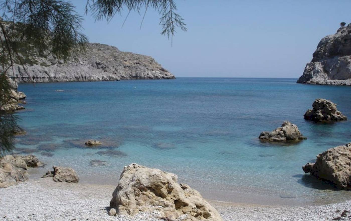 Strand des Irene Palace Beach Resorts mit kristallklarem Wasser und Felsen