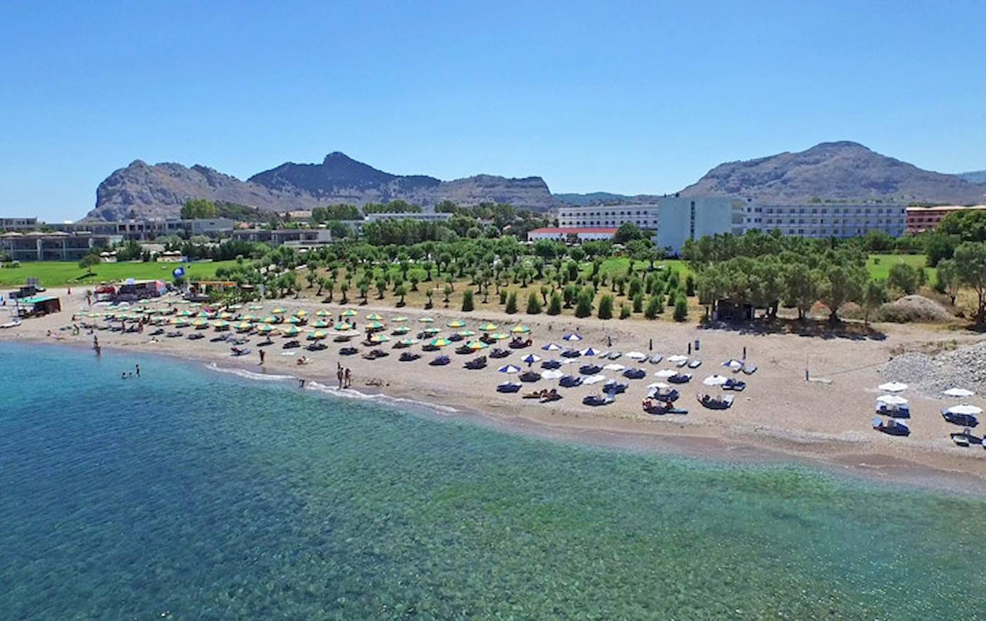 Luftaufnahme des Irene Palace Beach Resorts mit vielen Sonnenschirmen und Liegen am Strand