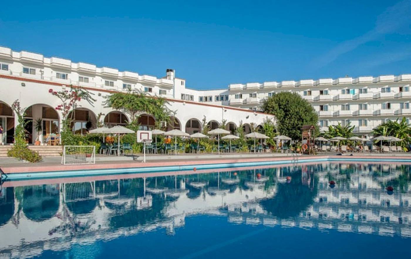 Außenbereich des Irene Palace Beach Resort mit Swimmingpool und Sonnenschirmen