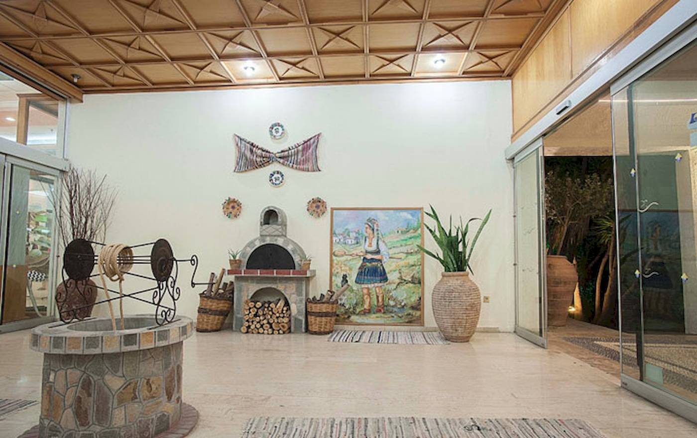 Innenbereich des Irene-Palast-Strandresorts mit Eingang, Ofen, Pflanzen und Wanddekorationen.