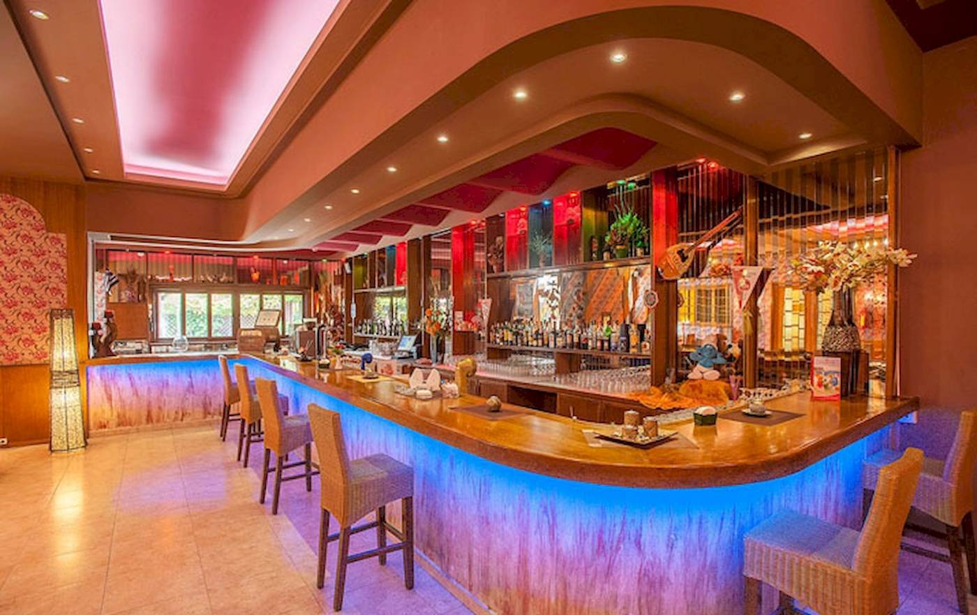 Bar im Irene Palace Beach Resort Hotel mit blauen Lichtern und Holztheke.