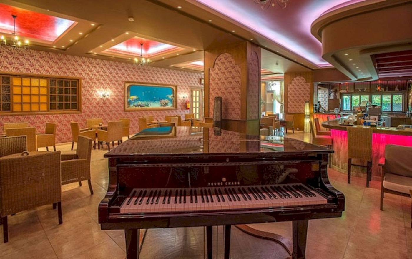 Bar im Irene Palace Beach Resort mit Klavier und farbiger Beleuchtung.