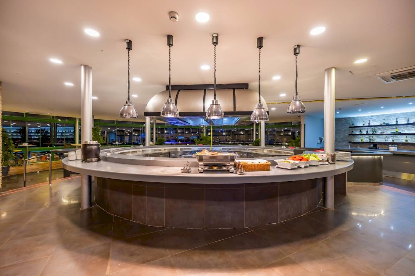 Innenbereich des Restaurants im VONRESORT Golden Coast mit einer Rundtheke und mehreren Lampen.