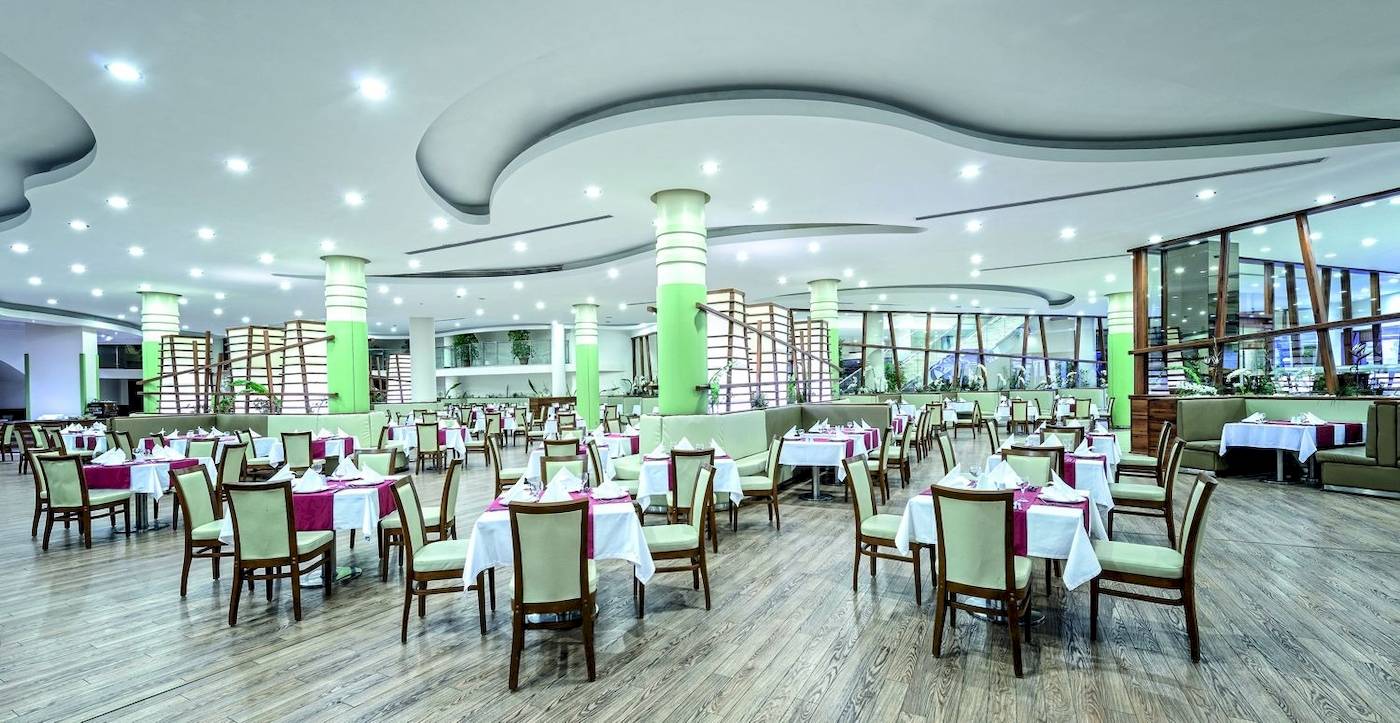 Restaurant im VONRESORT Golden Coast mit grünen Säulen und Holzboden