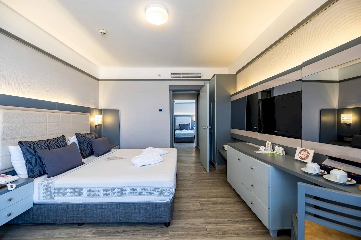 Vonresort Golden Coast Hotelzimmer mit großem Bett, Schränken und Fernseher.