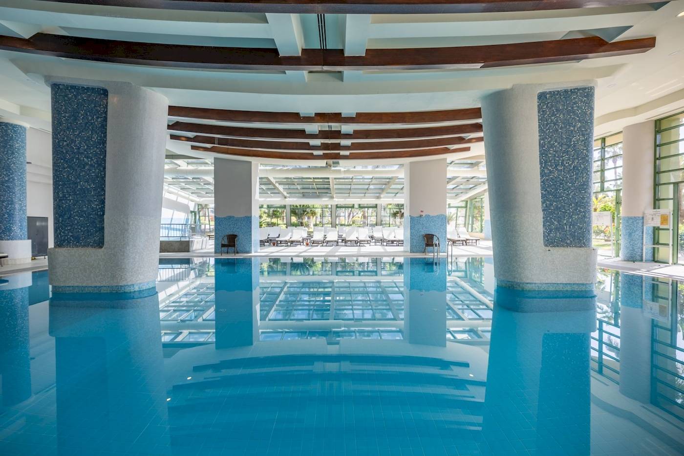 Innenpool des VONRESORT Golden Coast mit blauen Säulen und gefliestem Boden.