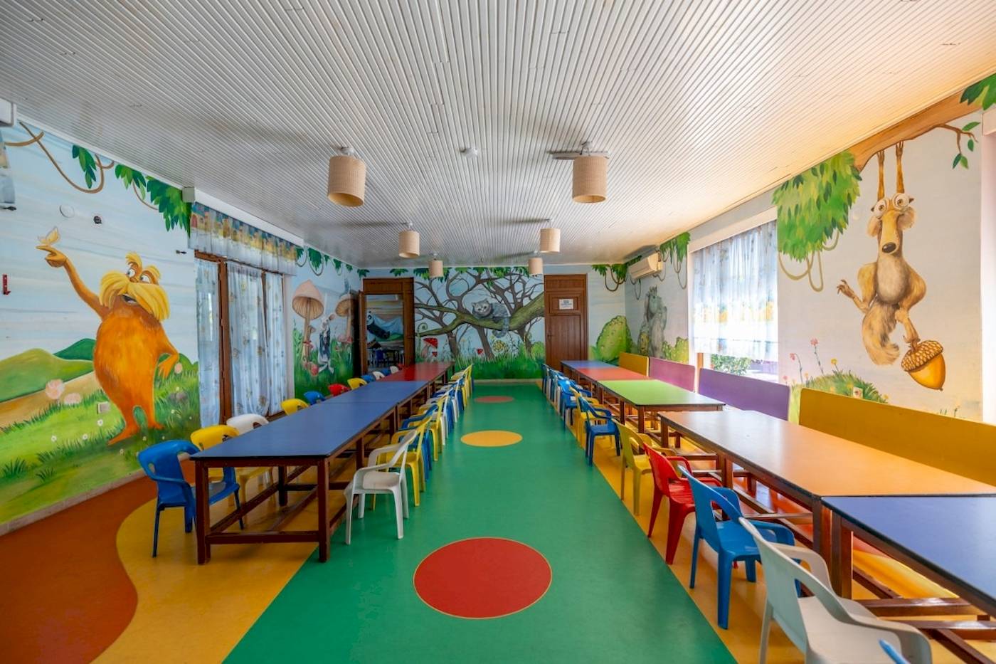 Kinderzimmer im VONRESORT Golden Coast mit grünem Boden und bunten Wandmalereien.