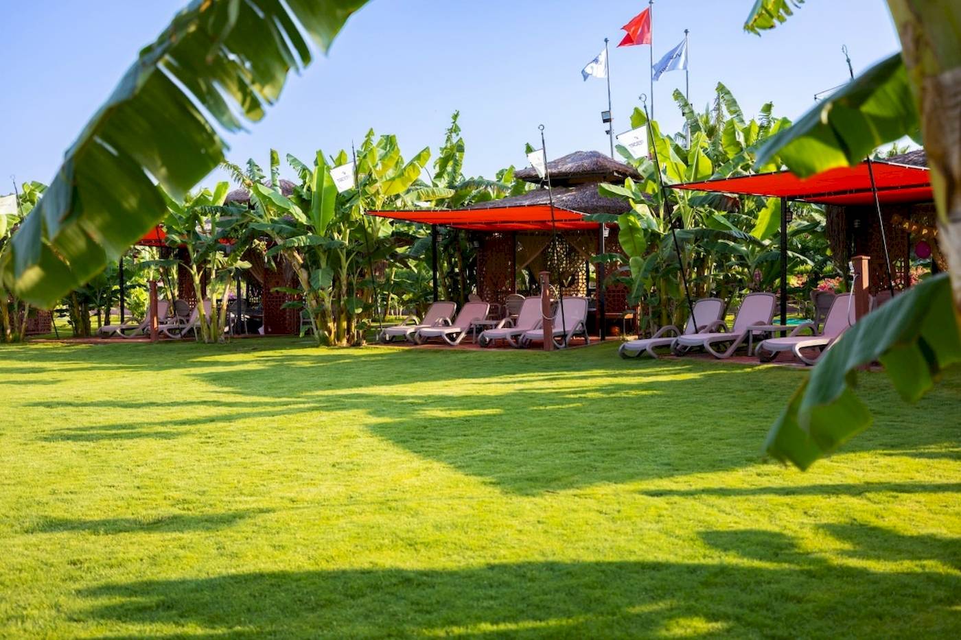 Loungebereich des VONRESORT Golden Coast mit Sonnenliegen und Pavillons.