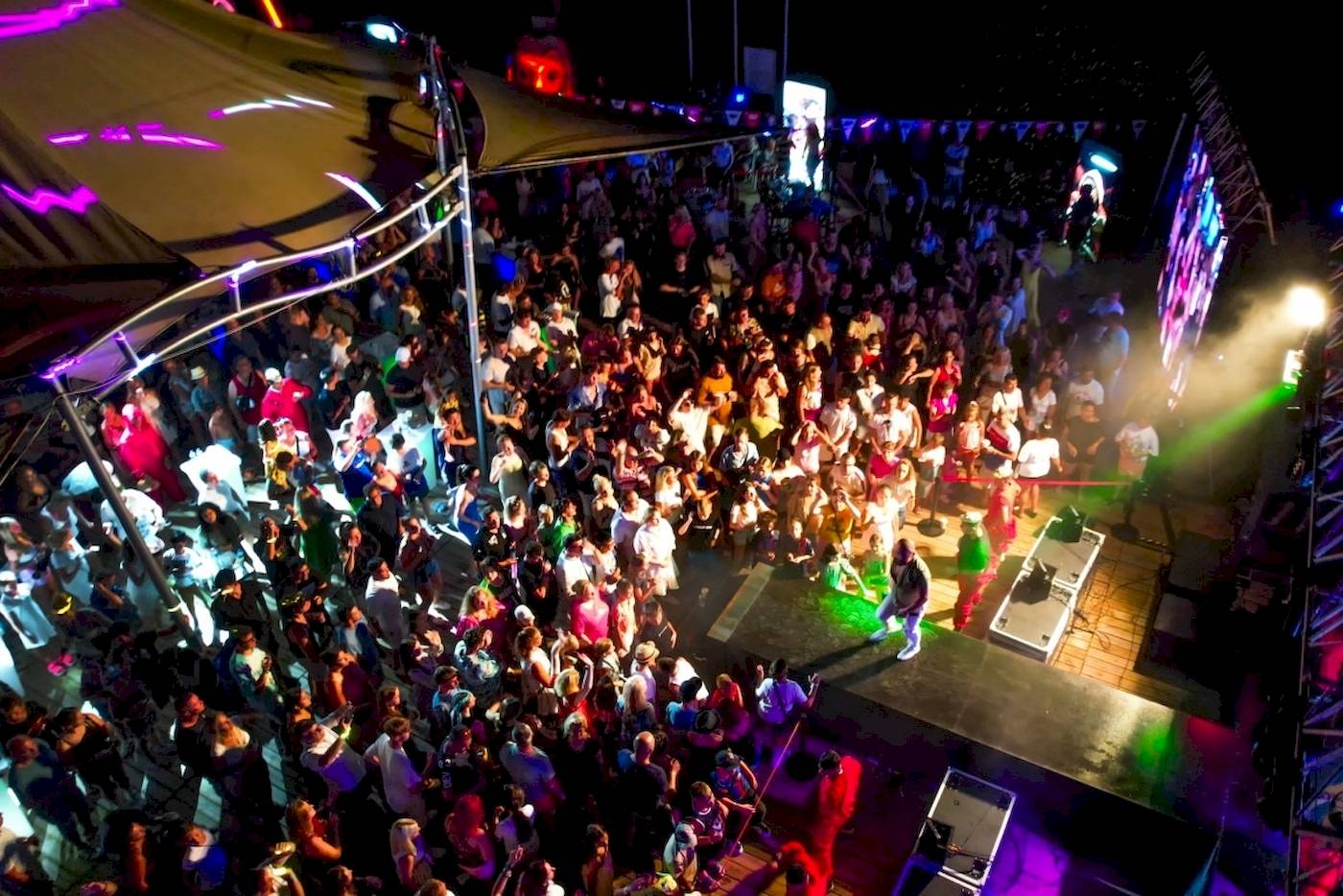 Foto eines vonresort golden coast nachtclub events mit vielen tanzenden leuten und bunten lichtern