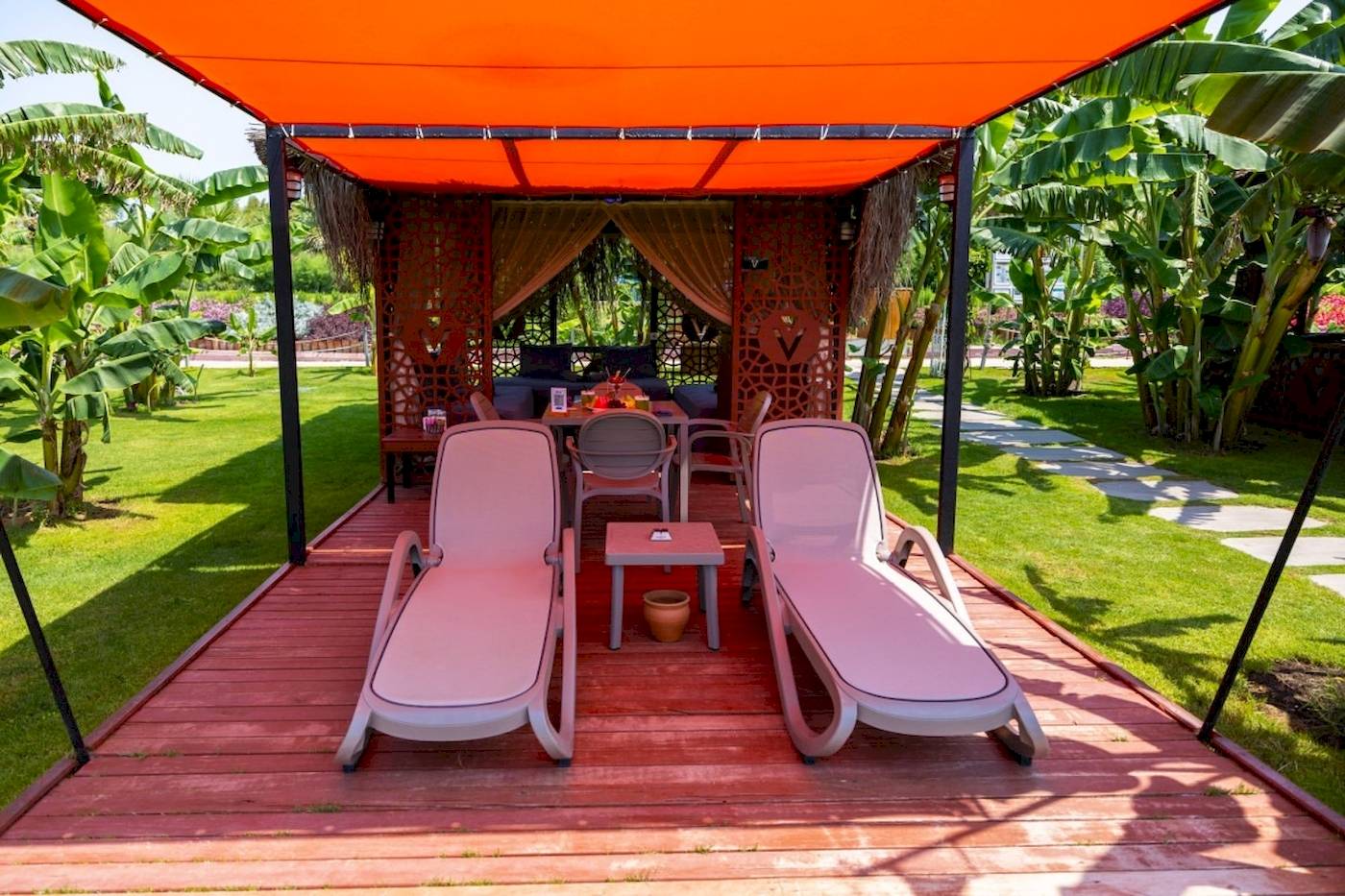 Lounge-Bereich des VONRESORT Golden Coast mit zwei pinken Liegen und einer Tisch.