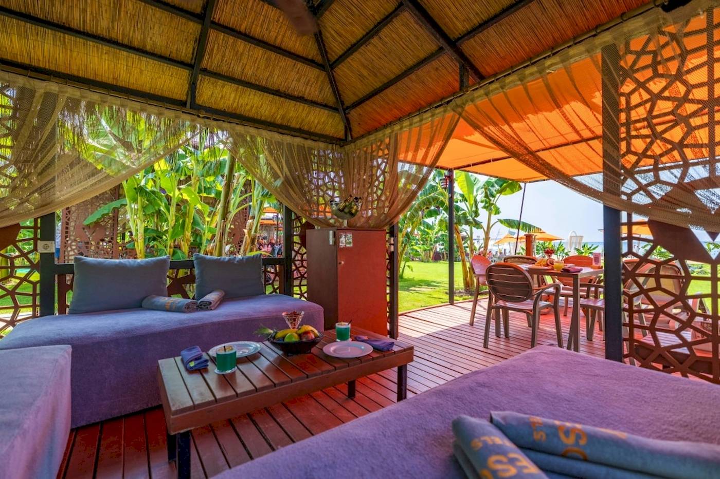 Terrasse im Vonresort Golden Coast mit Sofas, Tisch und Früchten