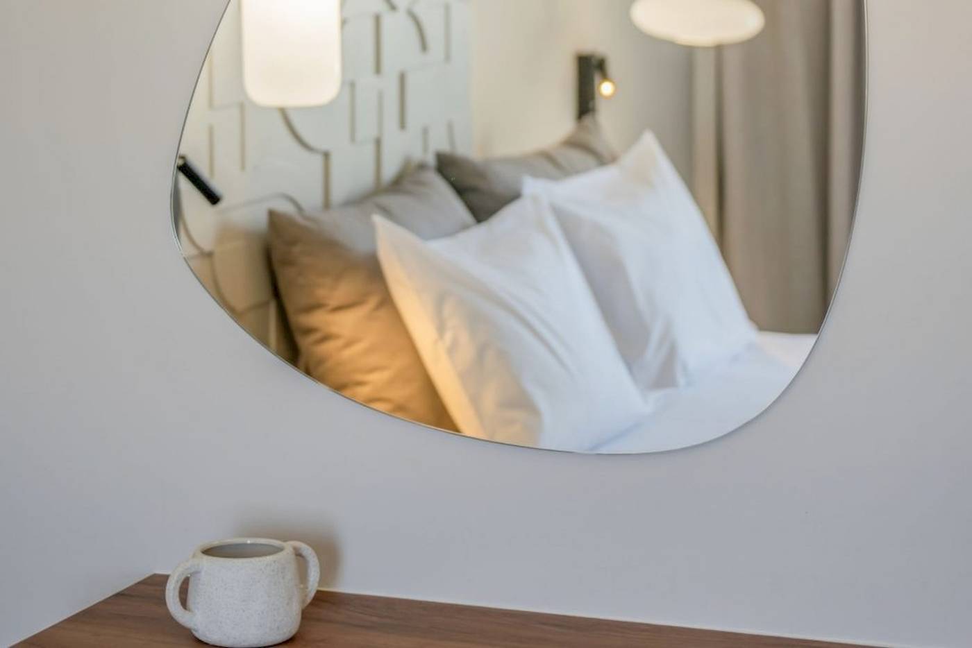 Ein Hotelzimmer im Georgioupolis Resort Aquapark & SPA mit einem Bett, das in einem Spiegel reflektiert wird.