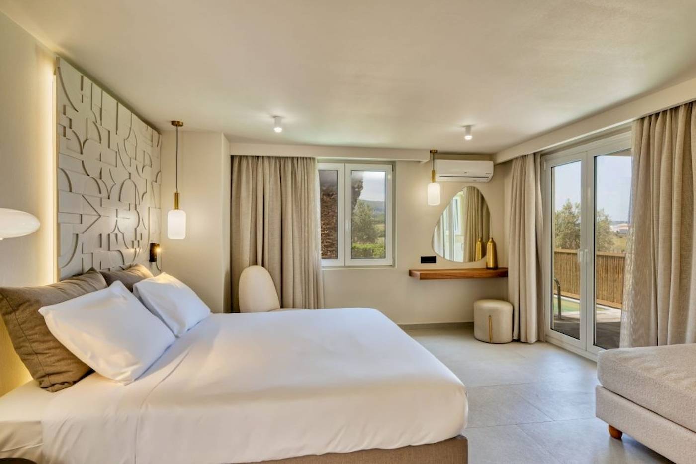 Schlafzimmer im Georgioupolis Resort Aquapark & SPA mit einem großen Bett, weißen Laken, Kissen, und offenem Fenster.