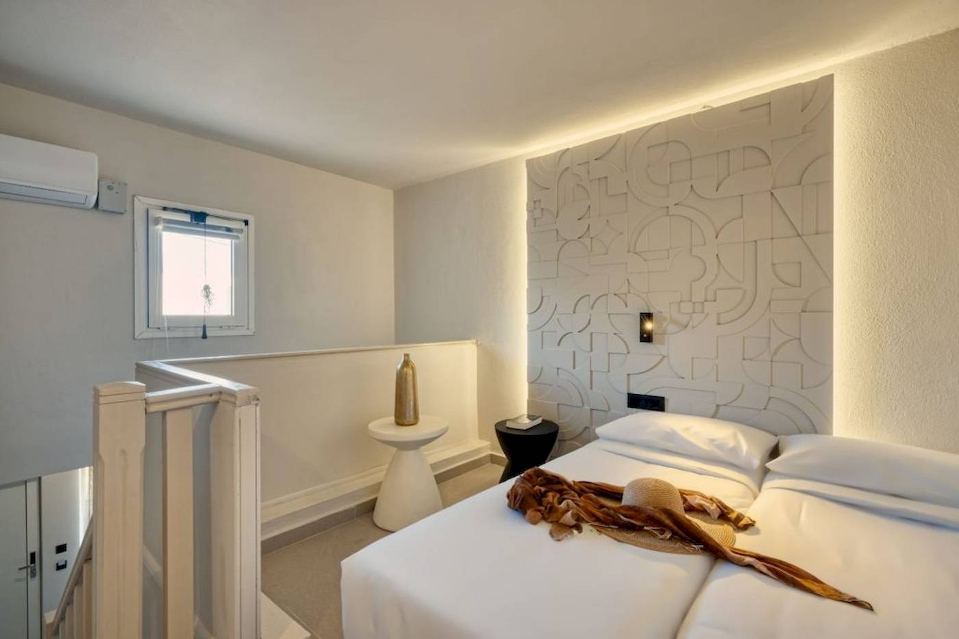 Innenansicht eines Schlafzimmers im Georgioupolis Resort Aquapark & SPA mit weißen Wänden, einem Bett, Nachttischen und einer Klimaanlage.