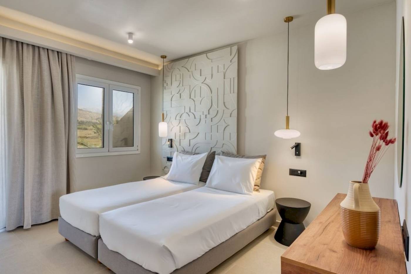 Innenansicht eines Doppelzimmers im Georgioupolis Resort Aquapark & SPA mit zwei Betten, weißem Bettzeug und moderner Einrichtung.