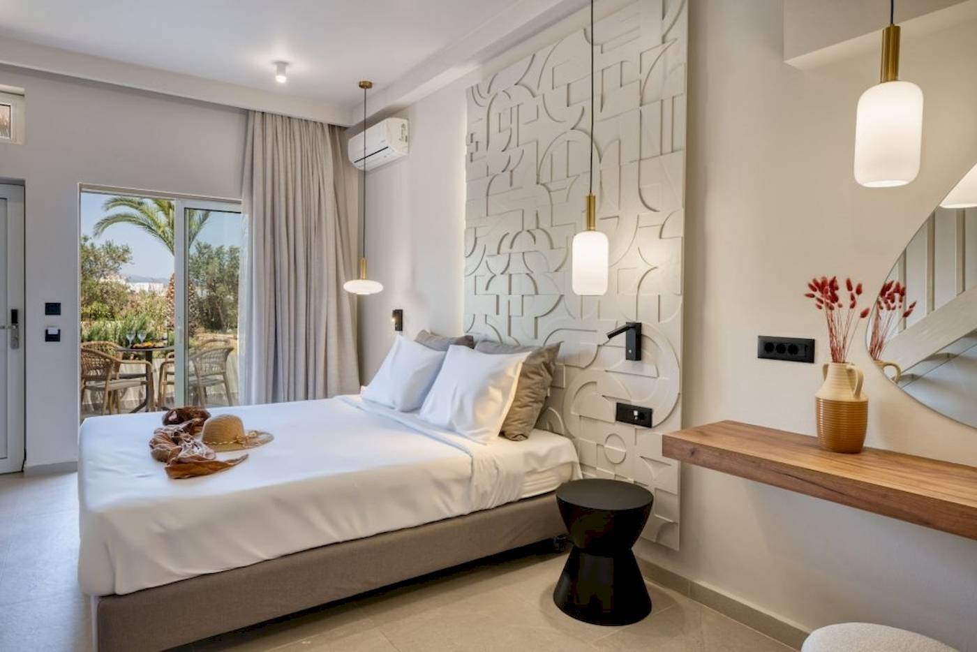 Innenansicht eines Schlafzimmers im Georgioupolis Resort Aquapark & SPA mit Bett, Dekor und Terrassenzugang.