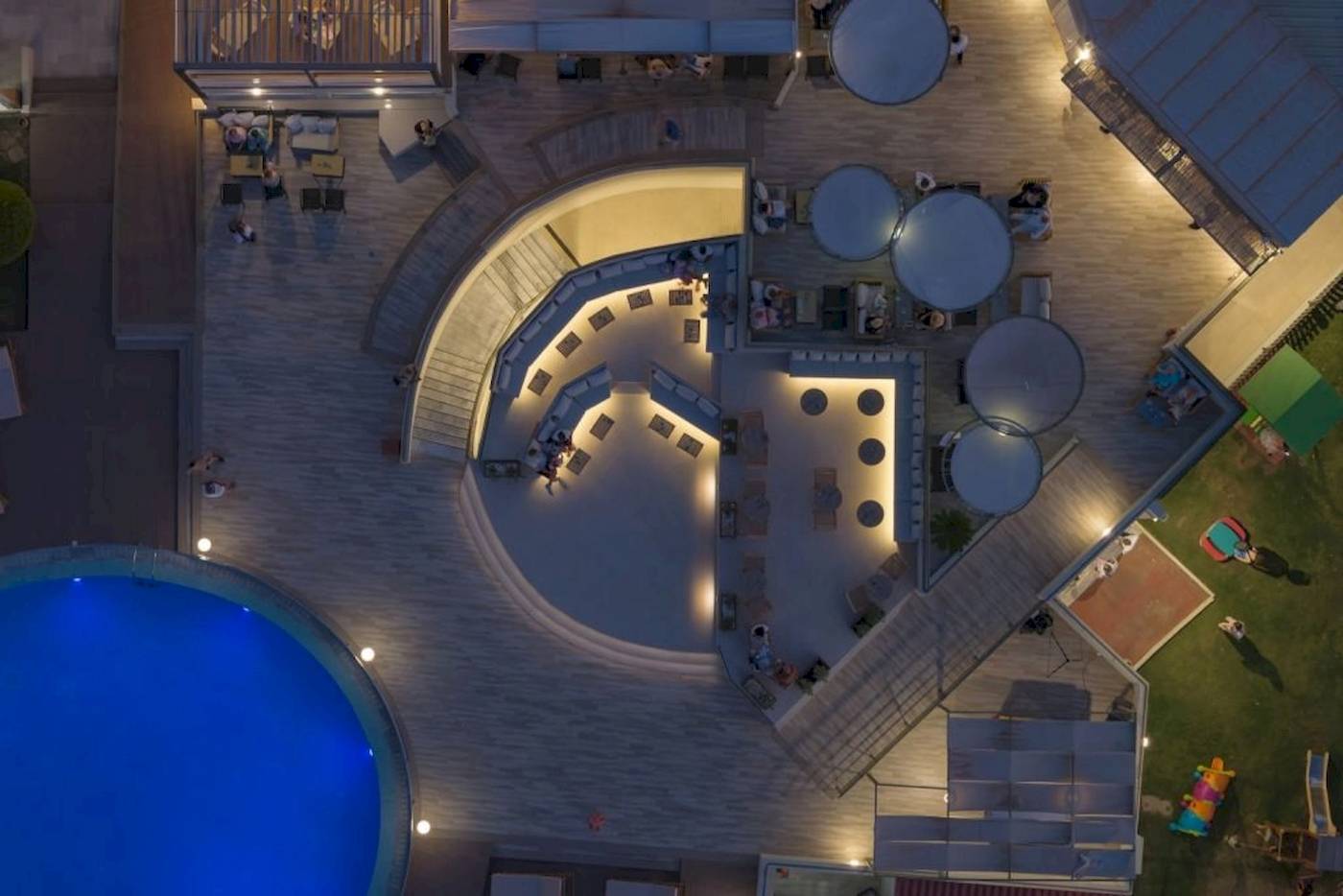 Luftbild des Georgioupolis Resort Aquapark & SPA bei Nacht mit beleuchteten Bereichen und Swimmingpool.