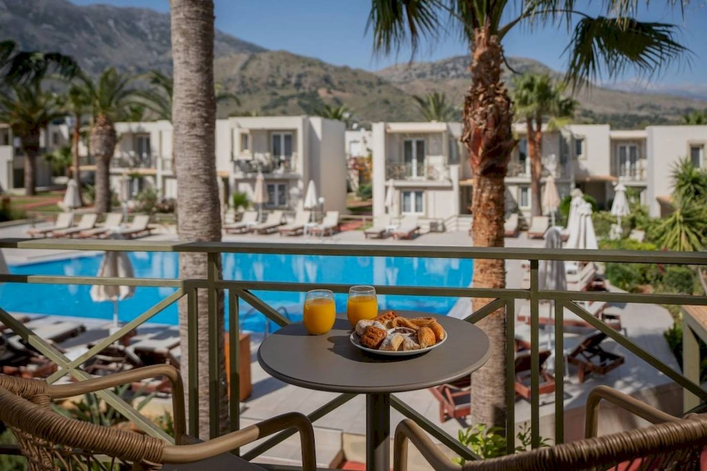 Frühstücksbuffet auf dem Balkon des Georgioupolis Resort Aquapark & SPA mit Blick auf den Pool und die Berge