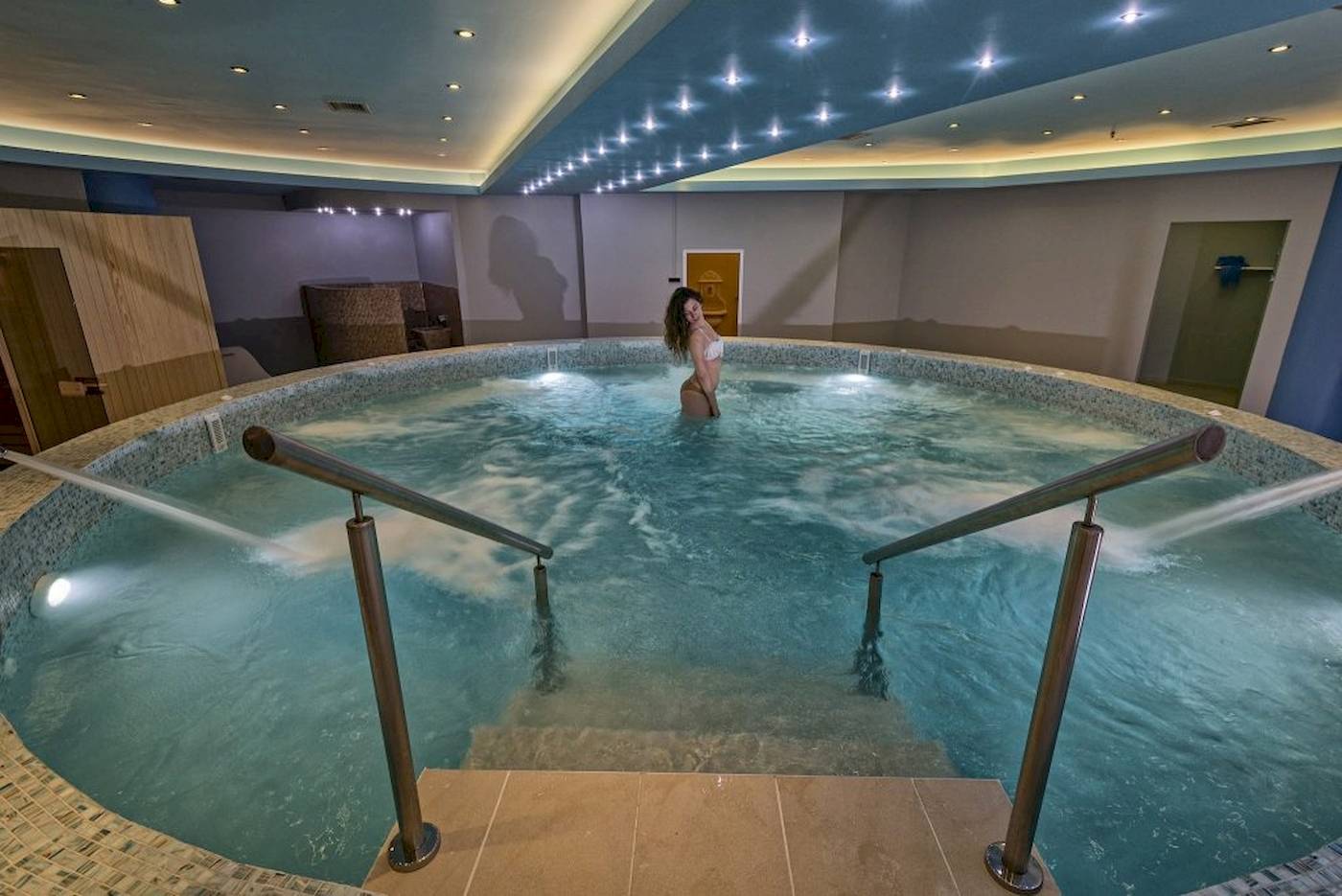Eine Frau steht in einem beheizten Innenpool des Georgioupolis Resort Aquapark & SPA.