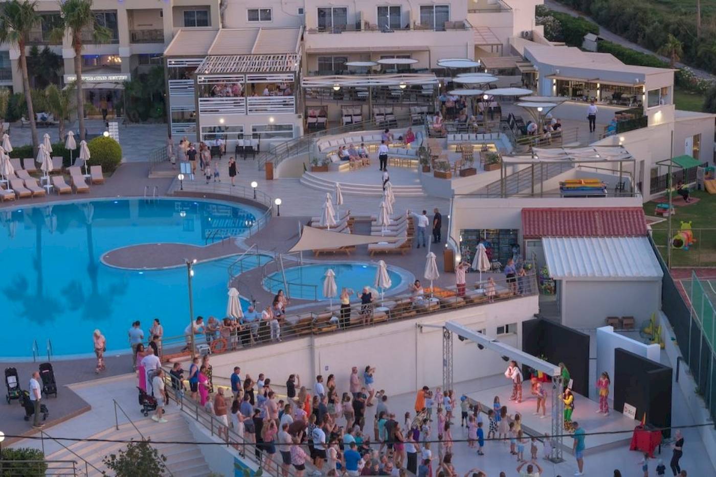 Georgioupolis Resort Aquapark & SPA Abendveranstaltung mit vielen Gästen an Pools und Terrassen.