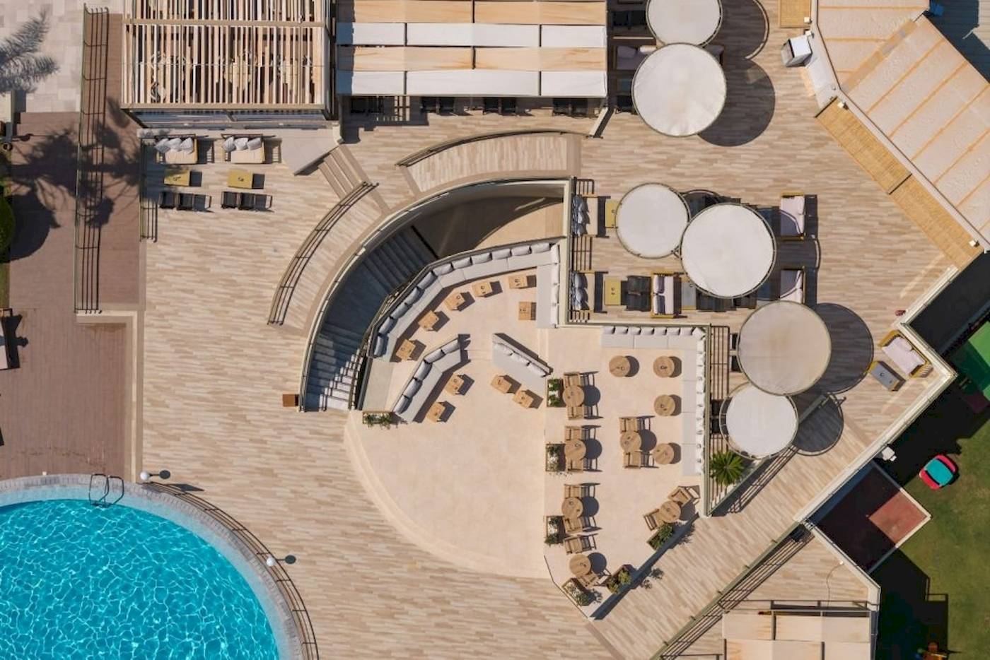 Luftaufnahme des Georgioupolis Resort Aquapark & SPA mit Poolbereich und Terrassenmöbeln.