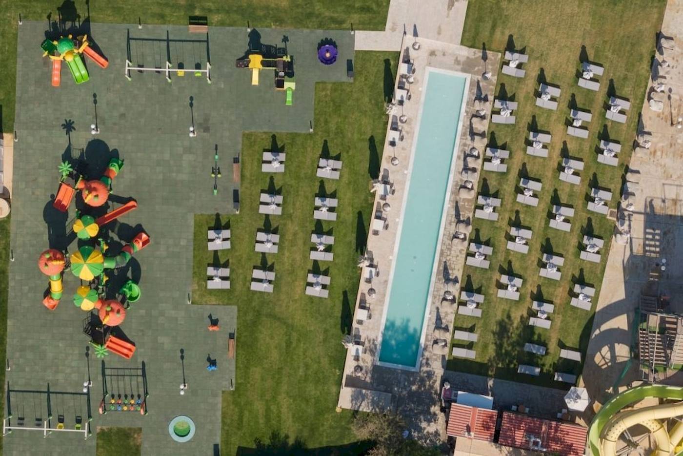 Luftaufnahme des Georgioupolis Resort Aquapark & SPA mit Wasserrutsche, Spielplatz und Sonnenliegen.