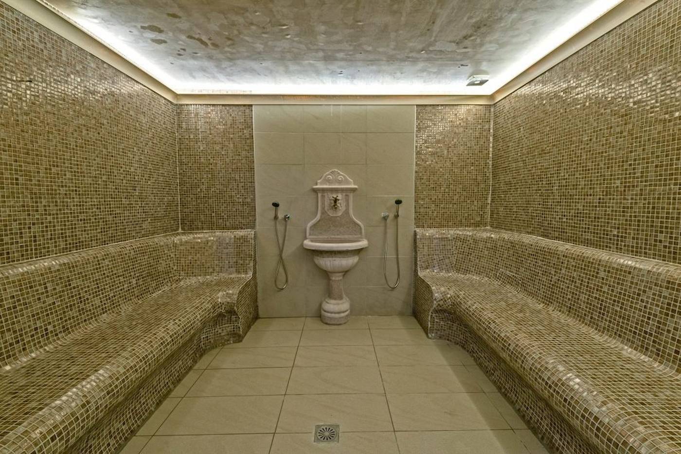 Saunaraum im Georgioupolis Resort Aquapark & SPA mit gefliesten Wänden und Bänken.