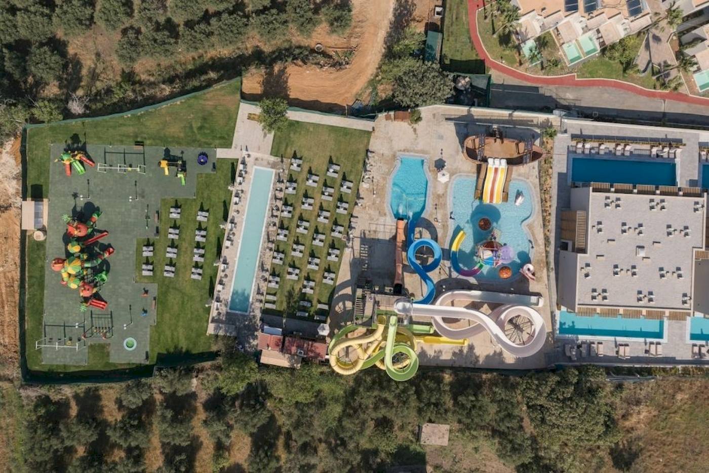 Luftaufnahme des Georgioupolis Resort Aquapark & SPA mit Pools, Wasserrutschen und Spielplatz.