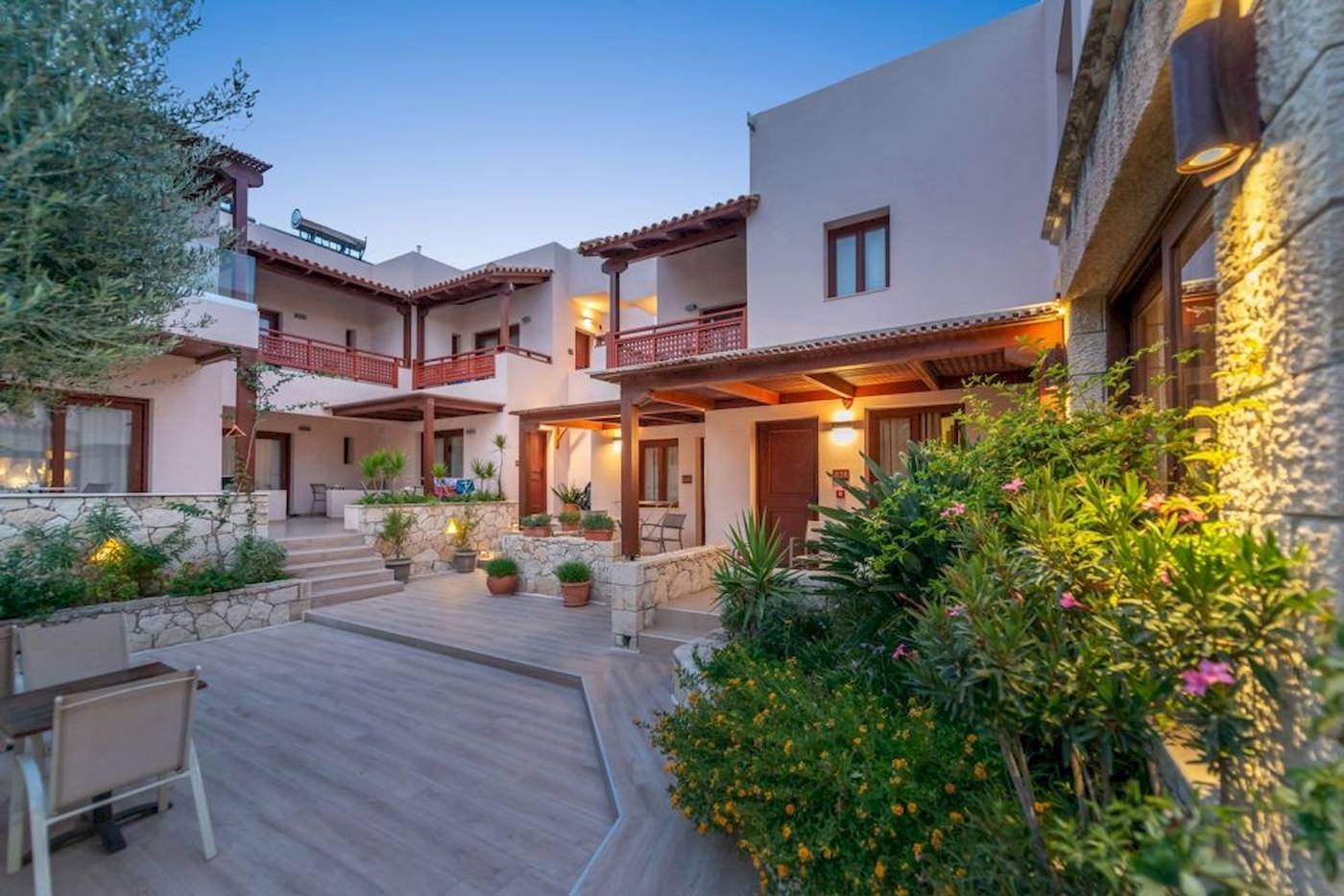 Außenbereich des Cactus Village Hotel & Bungalows mit Gehweg, Pflanzen und Gebäuden.