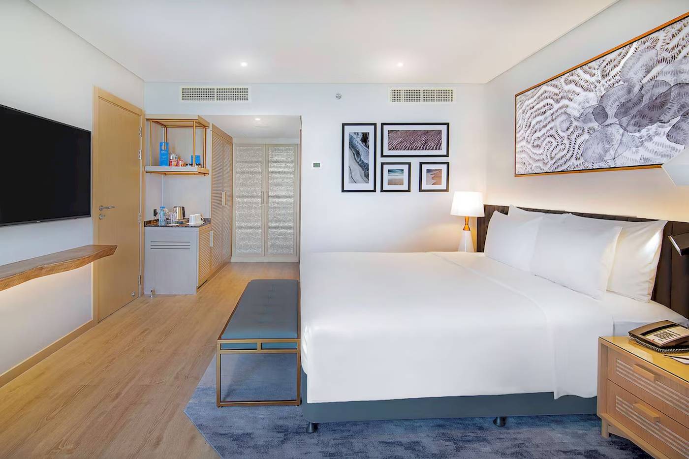 Innenansicht eines Gästezimmers im Radisson Blu Hotel & Resort, Abu Dhabi Corniche, mit Bett, Fernseher, und Dekor.