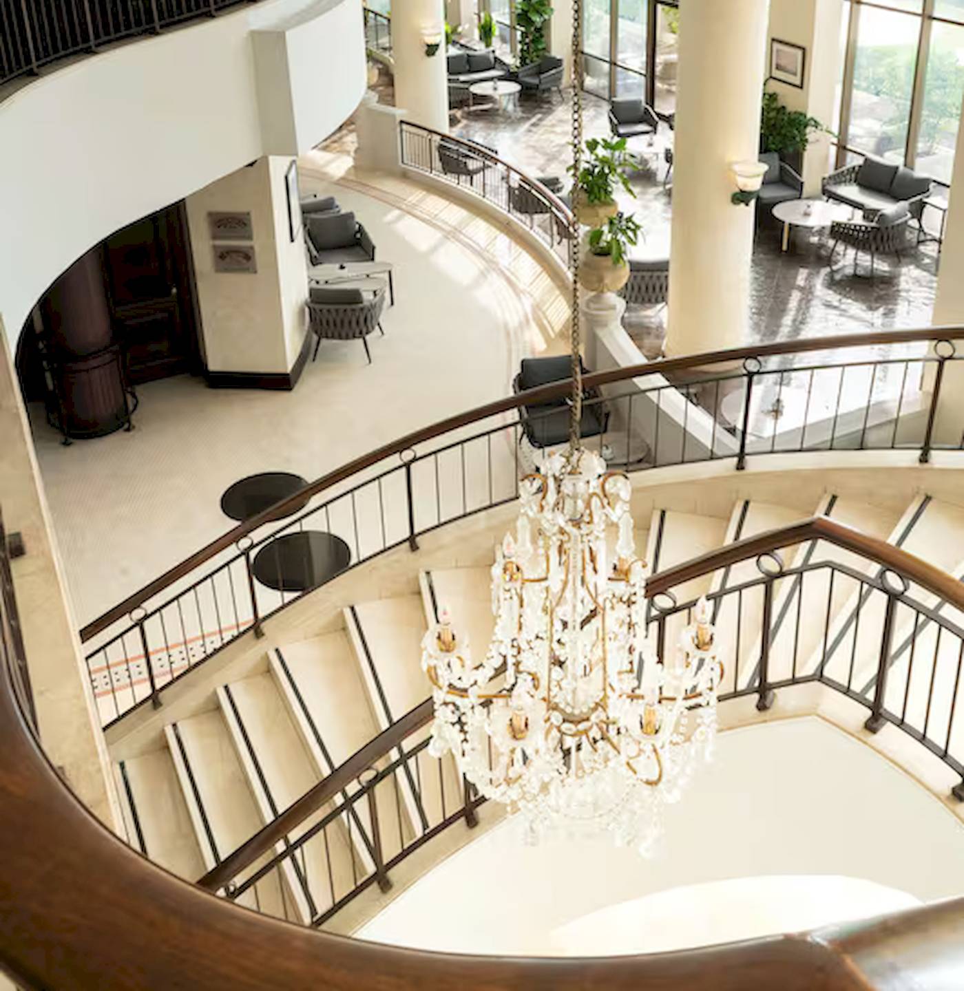 Innenansicht des Radisson Blu Hotel & Resort, Abu Dhabi Corniche mit einer großen Kristallleuchte und einer Wendeltreppe.