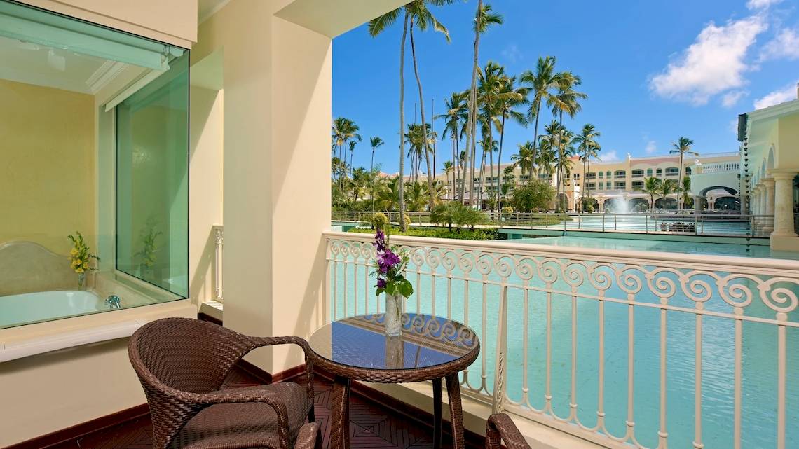 Balkon des JOIA Bávaro by Iberostar Hotels mit Blick auf einen Swimmingpool und Palmen.