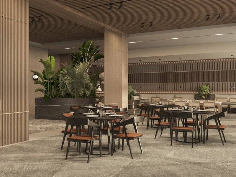 Innenbereich des Jaz Elite Amara Hotels mit Tisch und Stühlen, umgeben von Pflanzen.