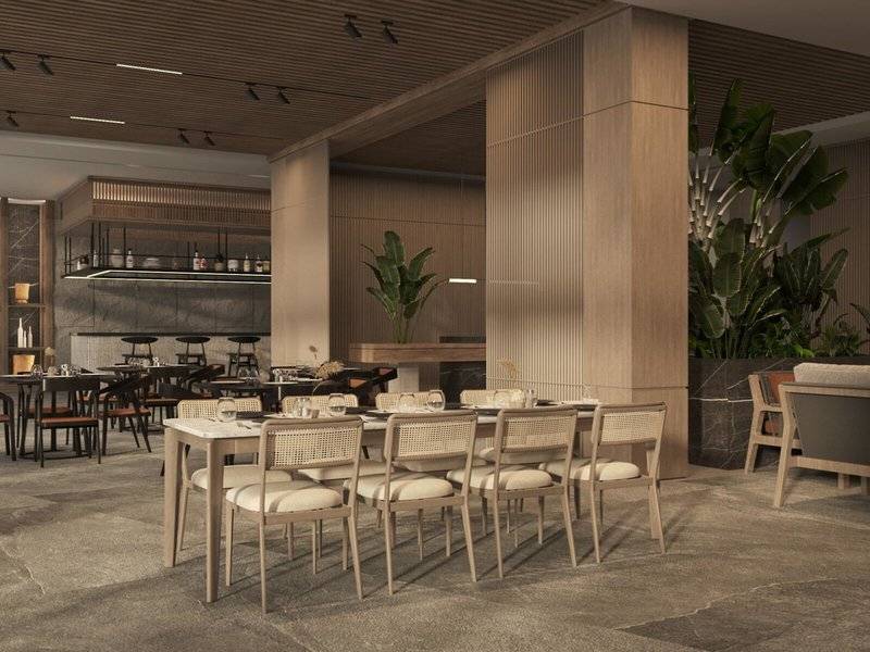 Innenansicht des Jaz Elite Amara Restaurants mit gedeckten Tischen und Stühlen, Holzsäulen und Pflanzen.