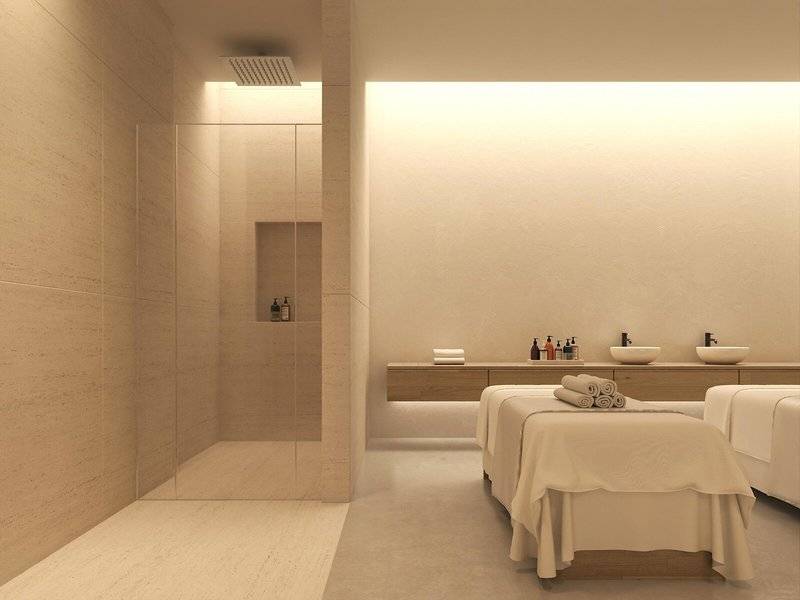 Massageraum im Jaz Elite Amara Hotel mit zwei Massagebetten, Dusche und Waschbecken.