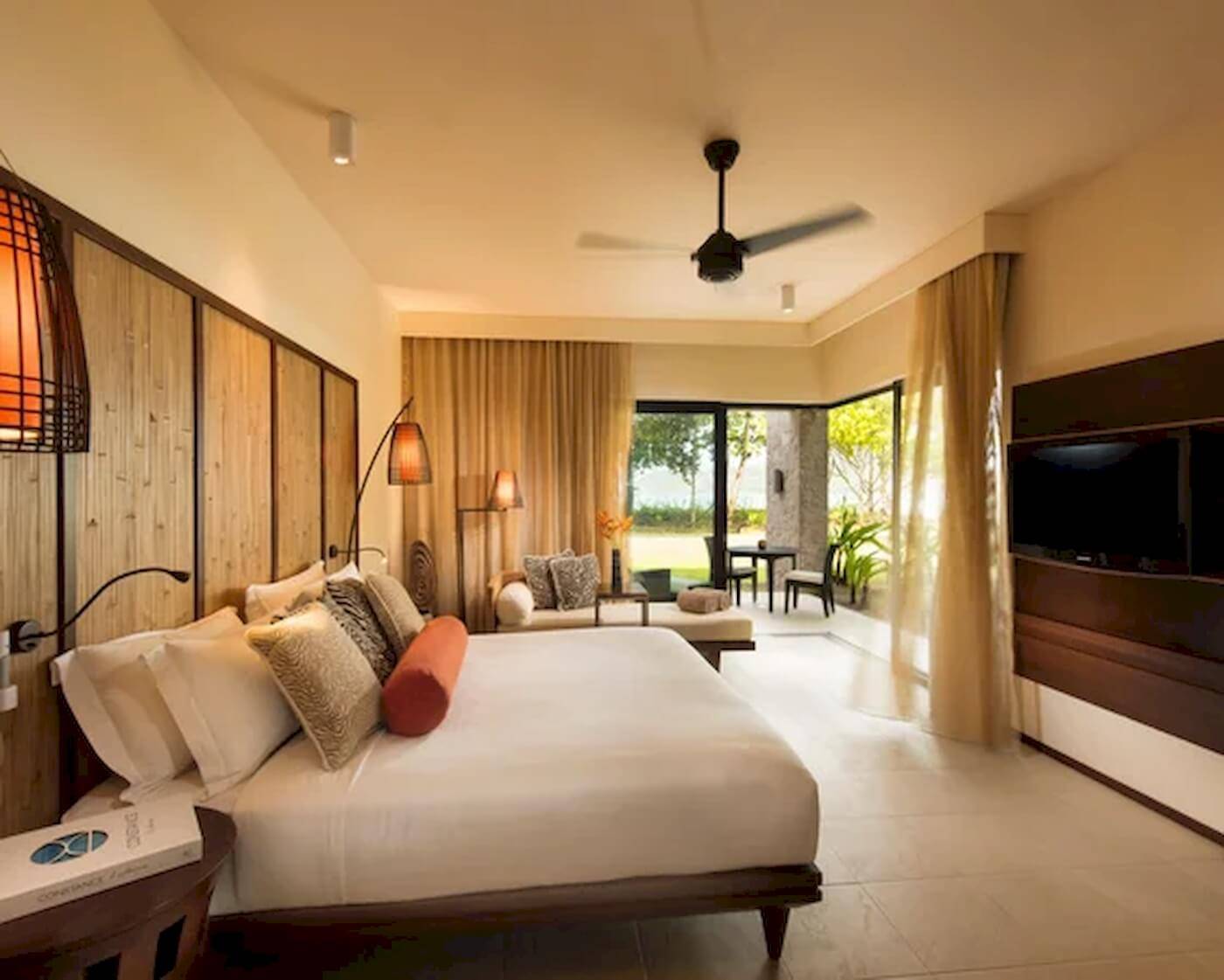 Schlafzimmer im Constance Ephelia Resort mit großem Bett, Fenstern und Blick auf die Terrasse.