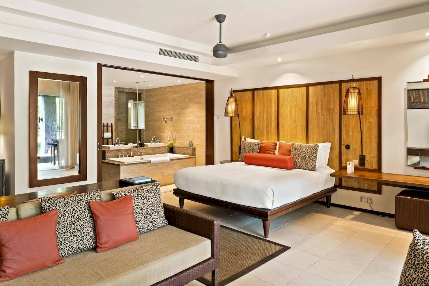 Innenansicht der Luxus-Suite im Constance Ephelia Resort mit Bett, Sofa und Badezimmer.