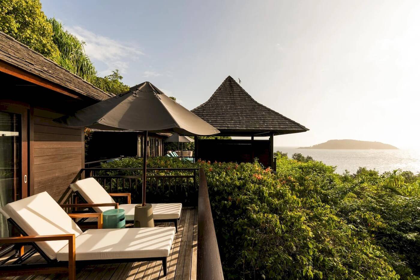 Terrasse mit Sonnenliegen im Constance Ephelia Resort mit Meerblick