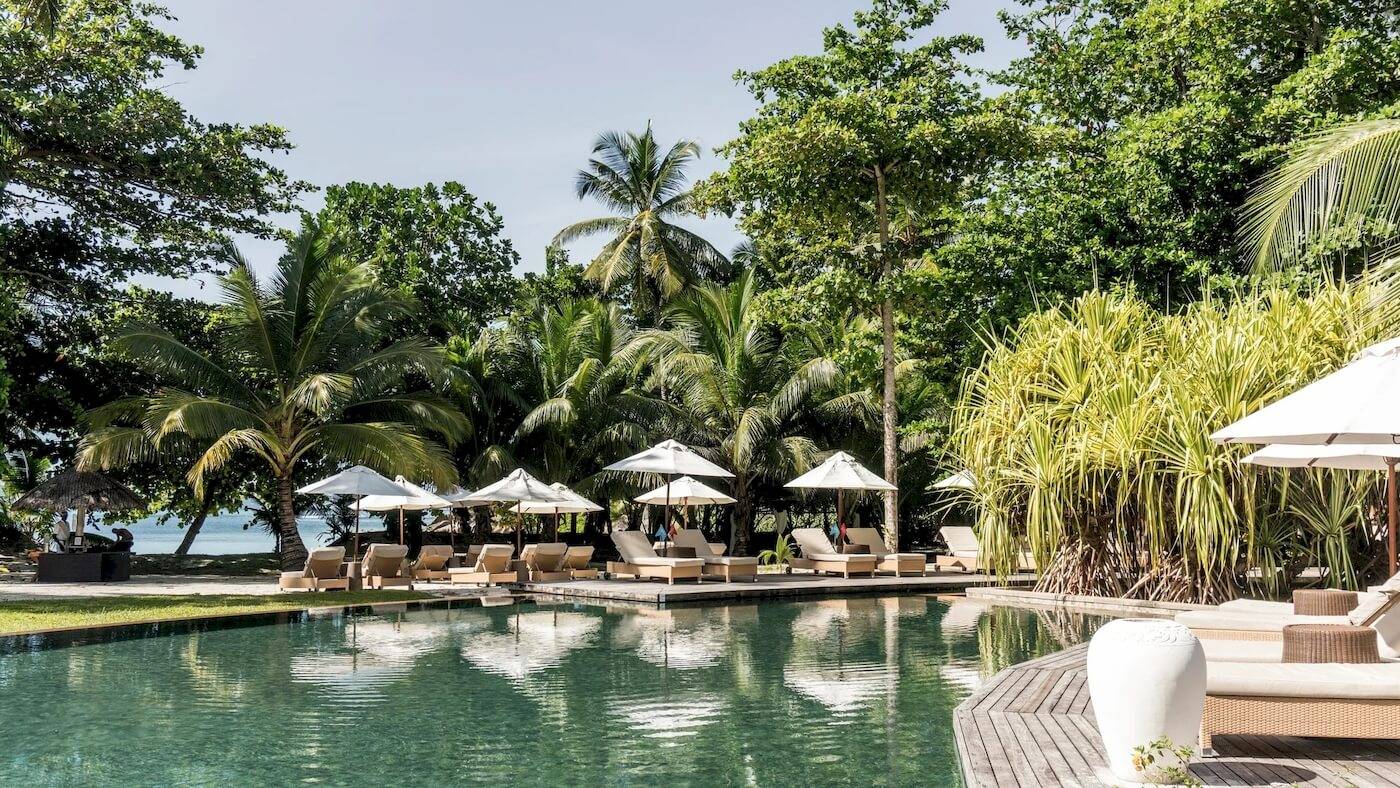 Constance Ephelia Resort Pool und Lounges mit Sonnenschirmen und Blick auf den Strand