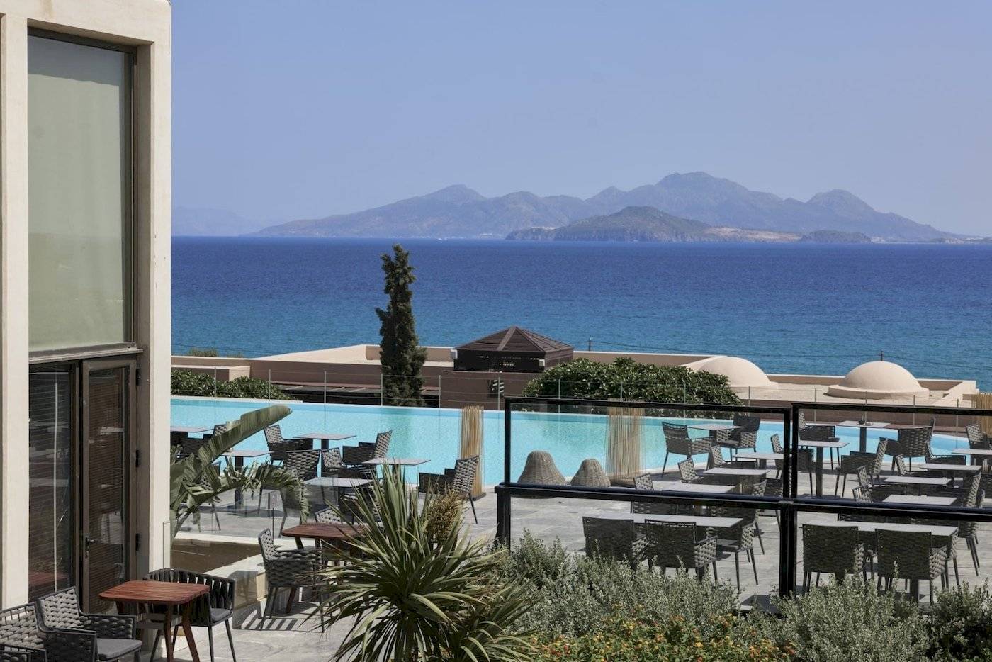 Außenbereich des Atlantica Beach Resort Kos mit Blick auf den Pool und die Berge.