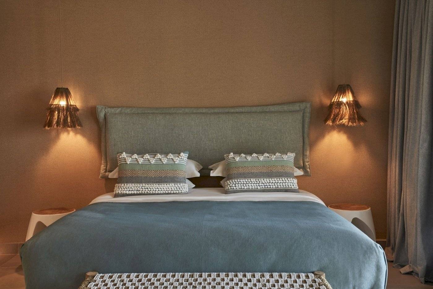 Schlafzimmer im Atlantica Beach Resort Kos mit zwei Nachttischen, dekorativen Lampen und einem bequemen Bett.